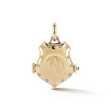 A structured, heirloom-worthy shield-shaped locket with diamond-set stars tracing the surface. Adding light, symbolism, and a sense of strength to its sculptural form.
At the center, a circular field is designed for personalization. A space for initials, numbers, or a mark that makes the piece distinctly your own. Thoughtful details continue throughout, including a cabochon blue sapphire opening inspired by traditional watch fobs. The locket is designed to hold photos or small keepsakes, creating space for